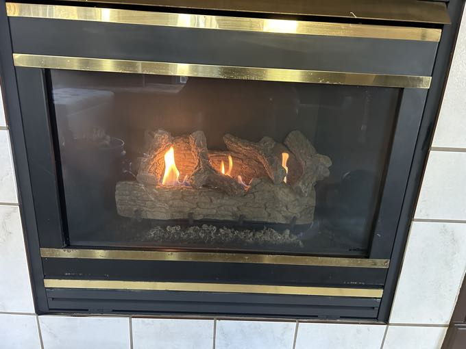 The same fireplace after service, burning with clean glass