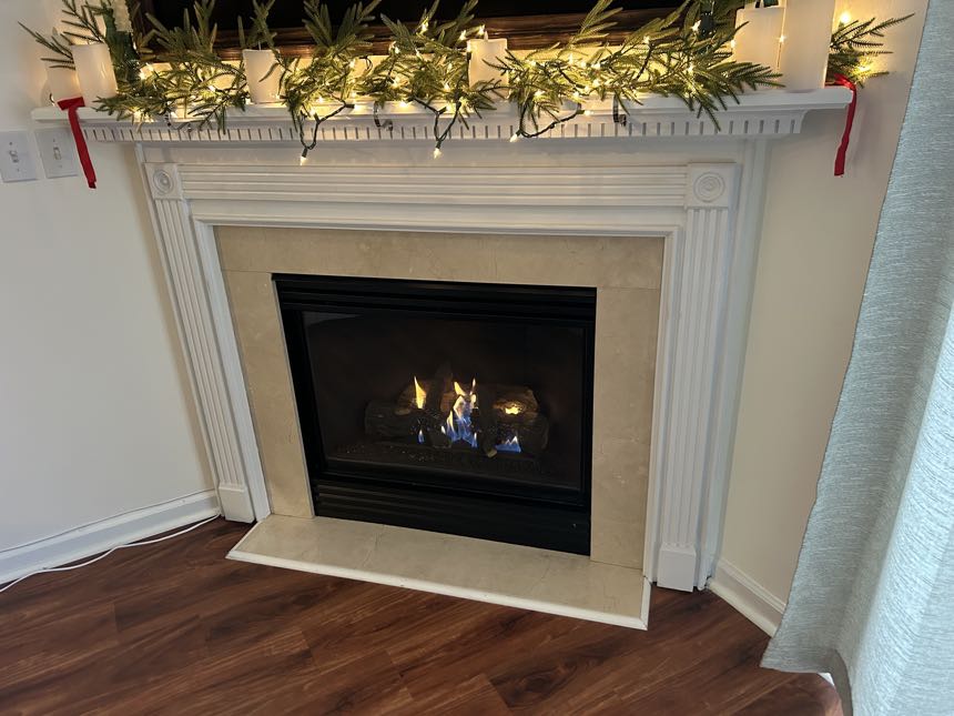 Gas fireplace burning cleanly in a white mantel surround